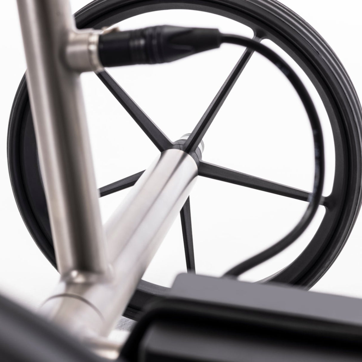 Elektro-Golftrolley TiCad Voyage 2025 mit GFK-Rädern und belederter Drehgriffsteuerung, silberner Rahmen.