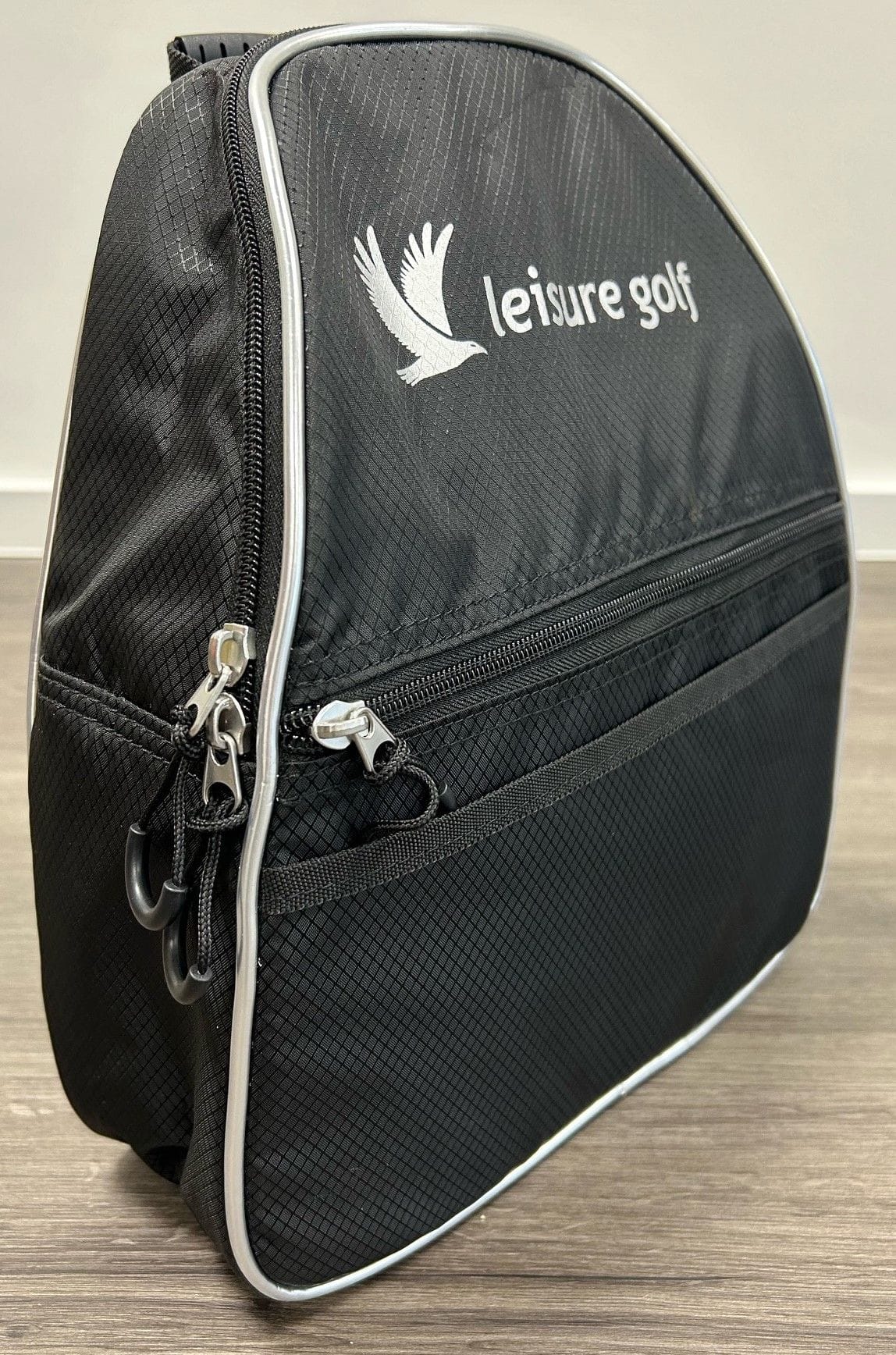 Schwarze Kühltasche aus Nylon mit weißer Paspelierung und Leisure Golf Logo, Reißverschlusstaschen vorne und an der Seite.