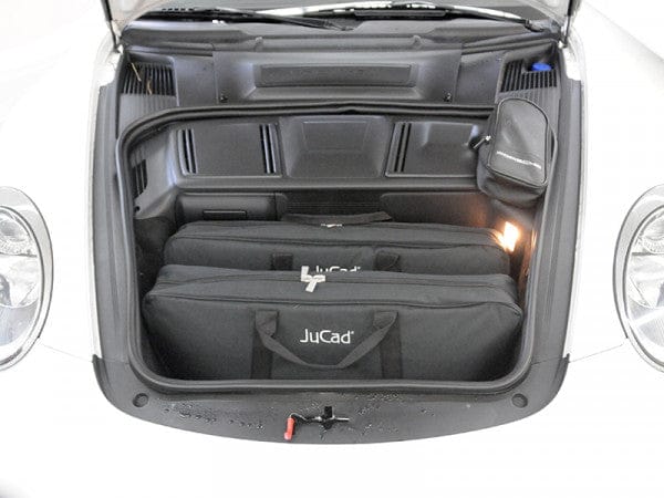 Schwarzer JuCad Carbon Travel Bianco SV 2.0 Golf-Trolleykoffer mit markantem JuCad-Logo im Autokofferraum.