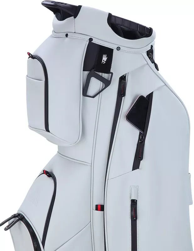 Taupefarbenes Big Max Dri Lite Prime Cartbag mit mehreren Reißverschlusstaschen und Griffen.