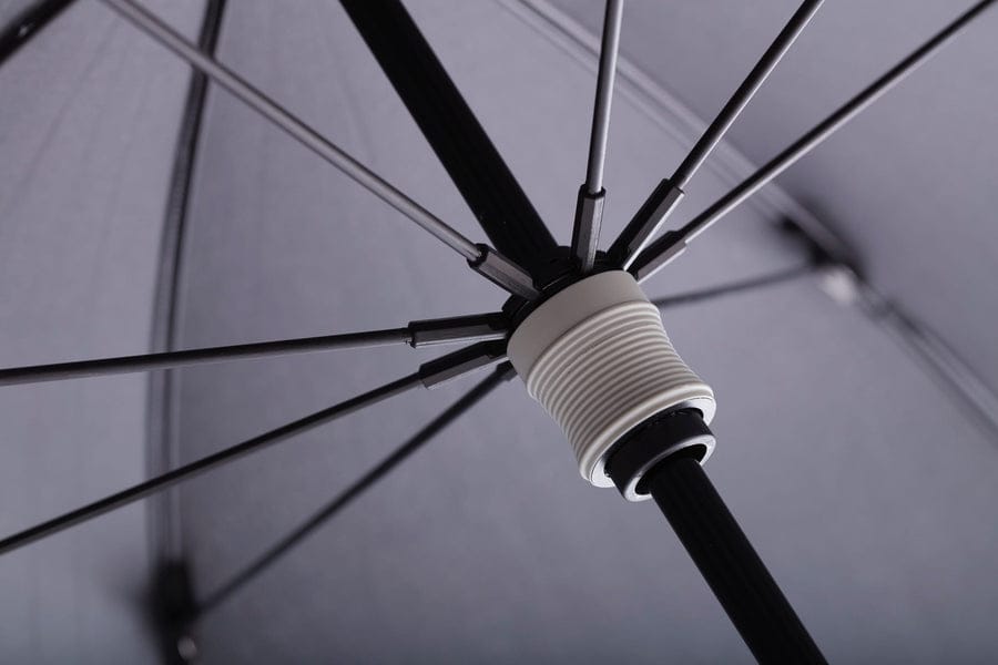 Schwarzer teleskopischer Regenschirm mit stabilem Metallgestell und weiß-riffelgem Griffdetail.