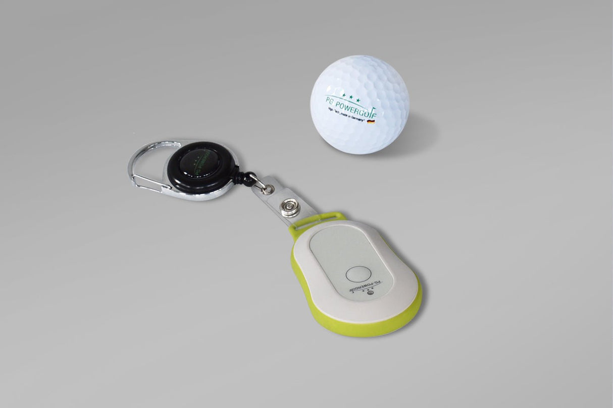 PG-Powergolf Fernbedienung mit Schlüsselanhänger neben Golfball, weiß und grün akzentuiert.