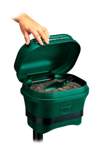 Grüner Divot Mate Ersatzständer niedrig mit offenem Deckel und Hand, die Reparaturwerkzeug herausnimmt.