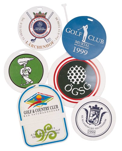 Fünf runde und ein rechteckiger weißer Aufkleber mit verschiedenen Golfclub-Logos und Nummern, zum Anbringen auf.