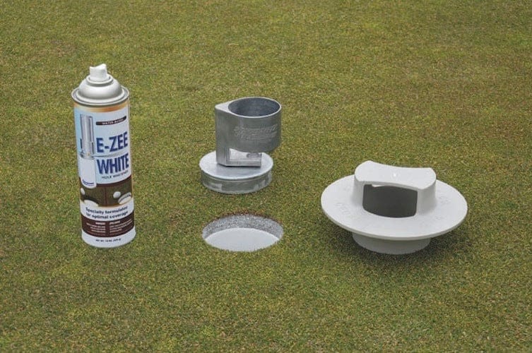 Weißer Sprühmarker mit Montageset auf Golfgrün, inklusive Halterungen und Einsetzstück.