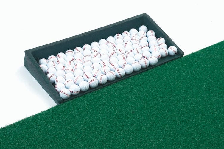 Schwarzes Balltablett aus Altgummi gefüllt mit 100 weißen Golfbällen auf grünem Kunstrasen.