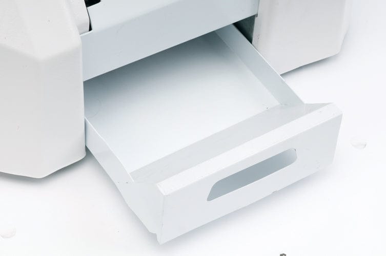 Offene weiße Kunststoff-Schublade mit Griff an grauem Gerät.