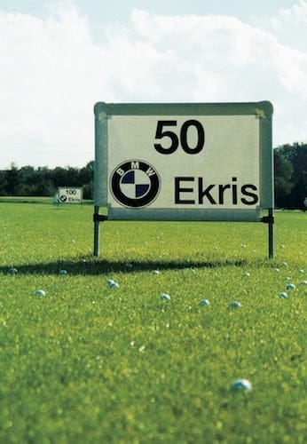 Werbebanner für Driving Range mit BMW-Logo und der Zahl 50, auf grünem Golfplatz.