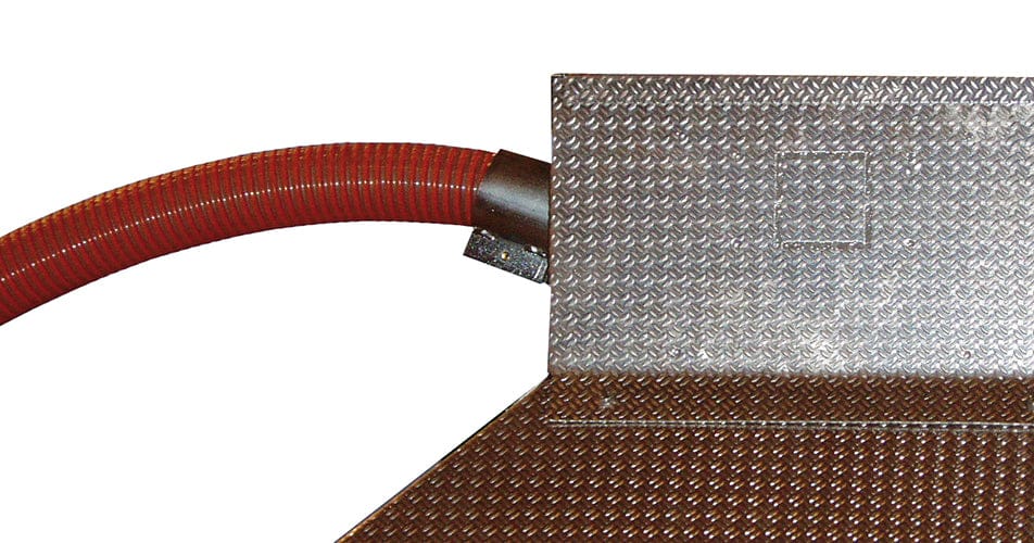 Roter flexibler Schlauch mit Metallanschluss am braunen, genoppten Metallblech.