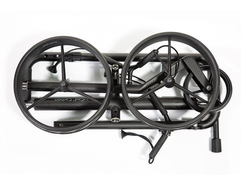 JuCad Carbon Travel Nero SV 2.0 Elektrotrolley zusammengefaltet in Schwarz mit Carbonrahmen und Zubehör.
