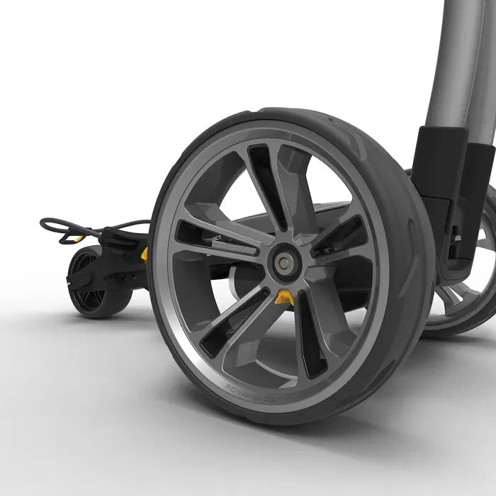 Großes vorderes Rad eines schwarzen elektrischen Golftrolleys mit grauen Speichen und gelben Details.