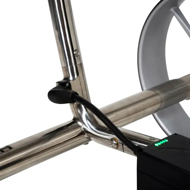 Silberner metallischer Rahmen mit schwarzem Verbindungselement und Teil eines grauen Rads am elektronischen Golftrolley.