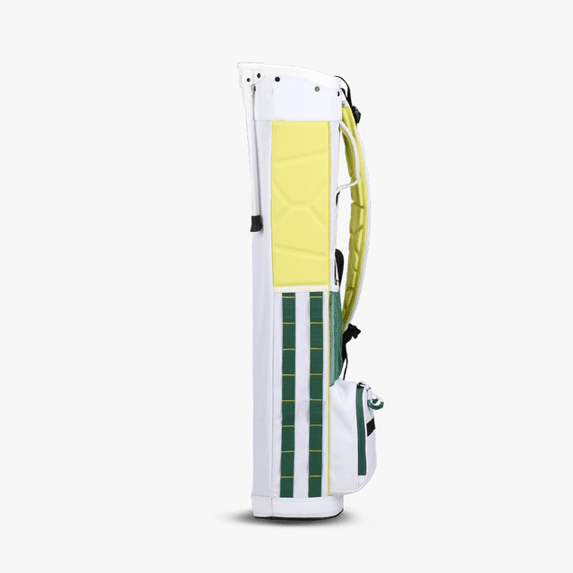 Weiß-gelbes OGIO Funday Stand Golfbag mit gestepptem Fach und grünem Karomuster, aufrecht stehend.